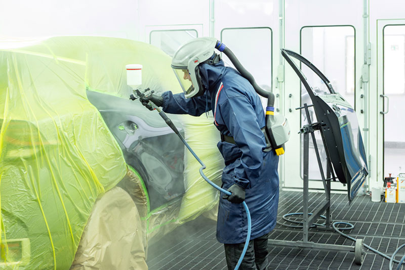 Lackierer lackiert Auto